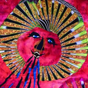 tapestry vignette of a red and gold sun blowing wind